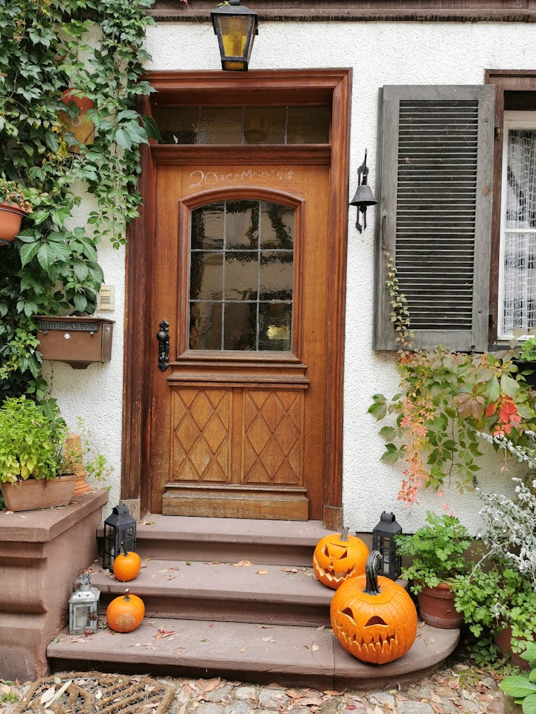 A warm, inviting porch decorated with Jack-o'-lanterns for Halloween in fall season.