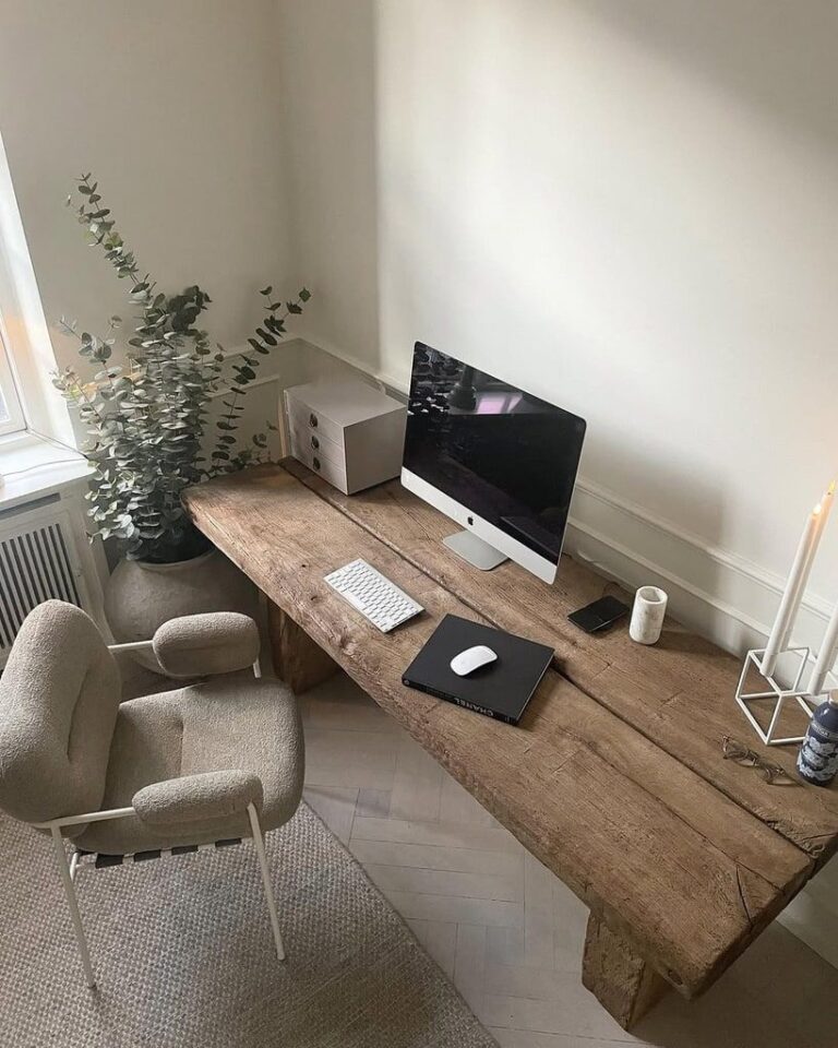 Cozy home office setup featuring a rustic wooden desk, beige armchairs, and a large potted plant.