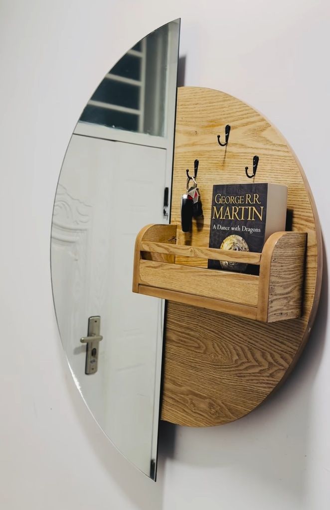 Round wooden entryway shelf with hooks and mirror for key and mail drop zone.
